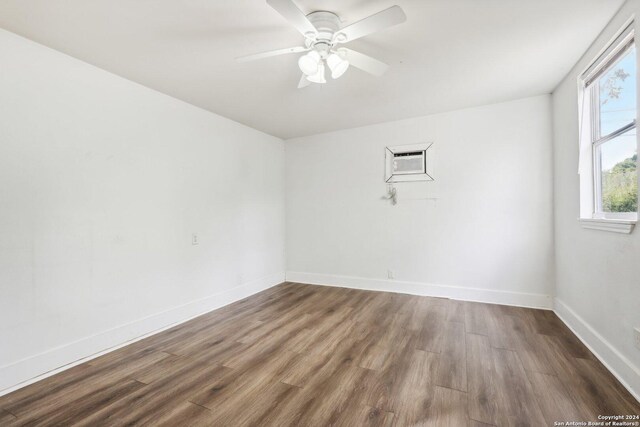 1112 W Huisache Ave, San Antonio, TX 78201 - unfurnished room featuring wood finished floors, a ceiling fan, baseboards, and a wall unit AC
