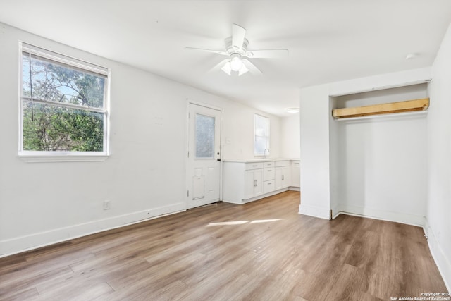 unfurnished bedroom featuring sink, light wood-type flooring, and ceiling fan