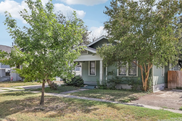 view of property hidden behind natural elements with a front yard