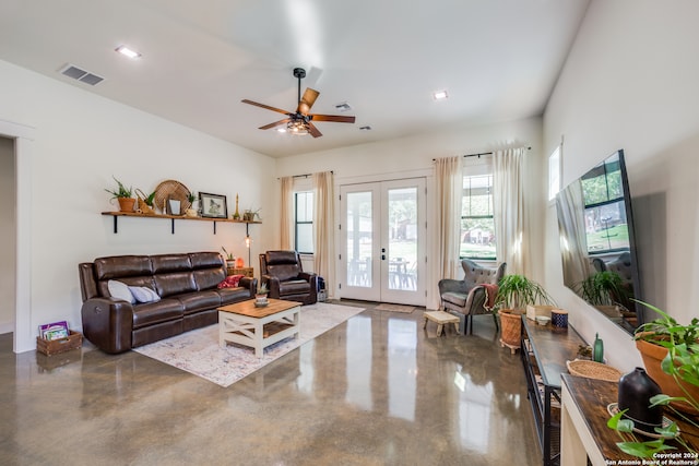 living room with french doors, ceiling fan, plenty of natural light, and concrete flooring