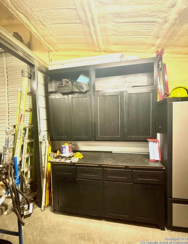 kitchen featuring dark brown cabinetry and fridge