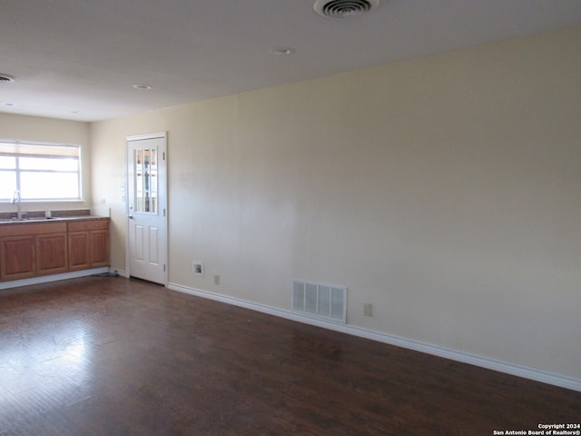 unfurnished room featuring dark hardwood / wood-style floors and sink