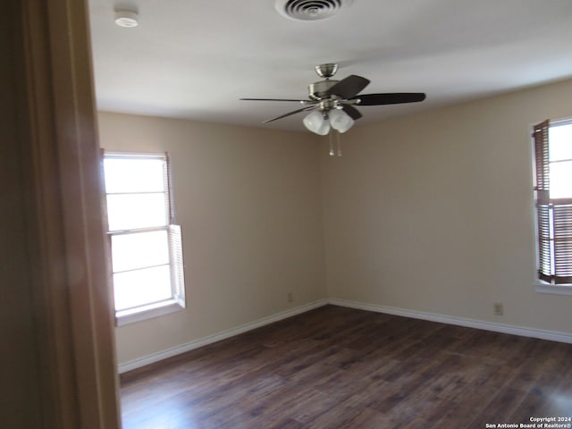 spare room with dark hardwood / wood-style floors, plenty of natural light, and ceiling fan