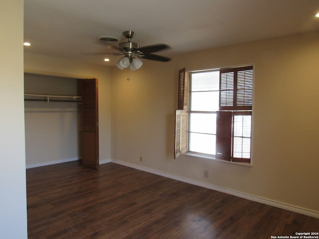 unfurnished bedroom featuring dark wood-type flooring, ceiling fan, and a closet