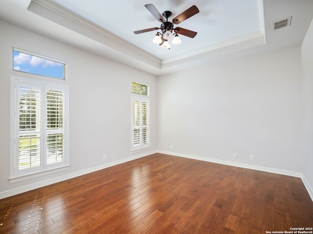 unfurnished room with ceiling fan, a tray ceiling, and hardwood / wood-style floors