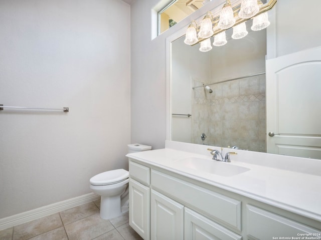 bathroom with vanity, toilet, tile patterned floors, and tiled shower