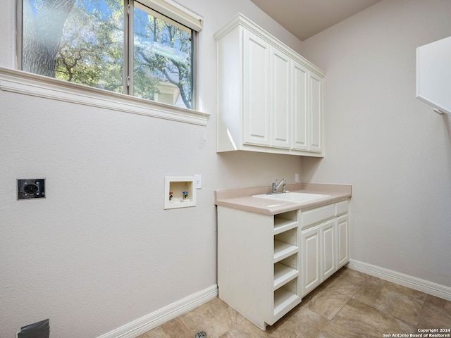 laundry room with electric dryer hookup, washer hookup, sink, light tile patterned flooring, and cabinets