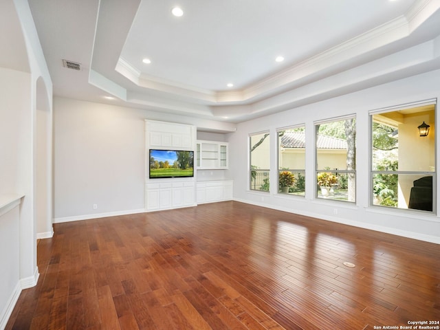 unfurnished living room with crown molding, dark hardwood / wood-style floors, and a raised ceiling