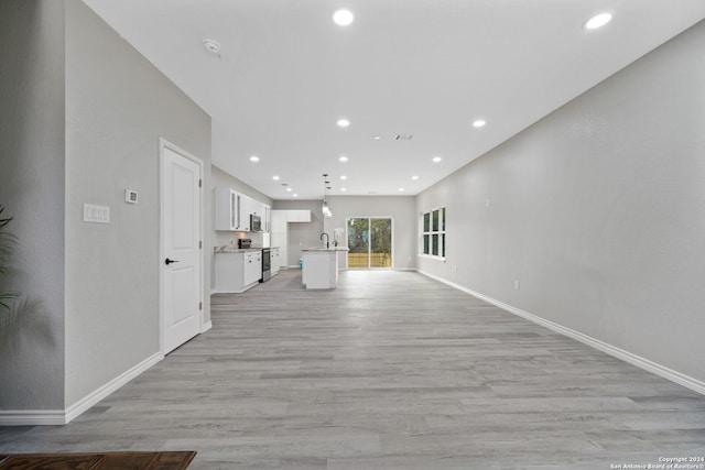 unfurnished living room with sink and light hardwood / wood-style flooring