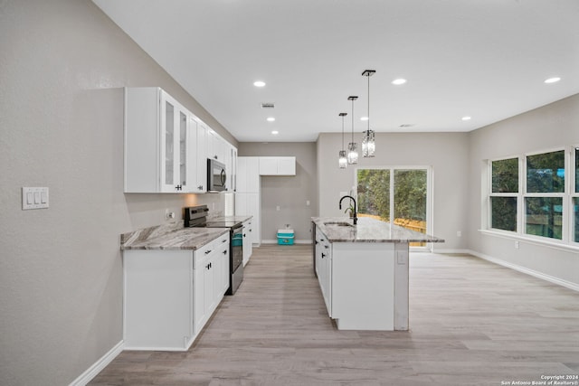 kitchen featuring white cabinetry, appliances with stainless steel finishes, sink, and an island with sink