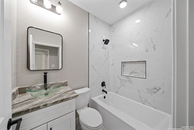 full bathroom featuring tiled shower / bath, vanity, and toilet