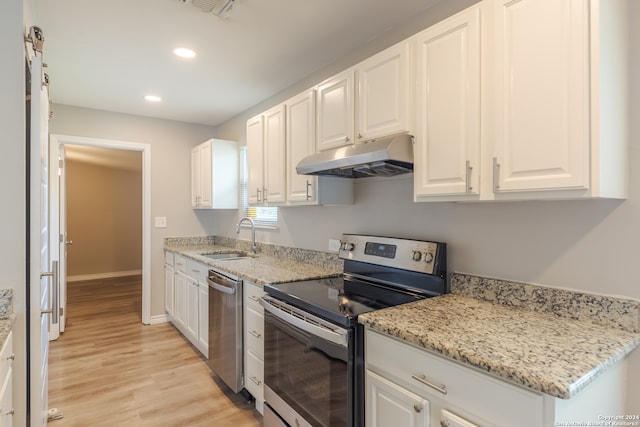 kitchen featuring white cabinetry, stainless steel appliances, sink, and light wood-type flooring