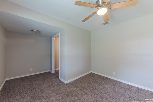 empty room featuring ceiling fan and dark carpet