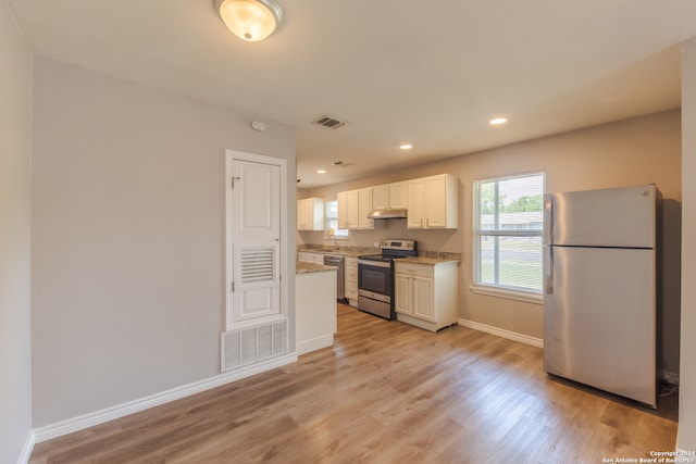 kitchen featuring light stone countertops, sink, white cabinetry, stainless steel appliances, and light hardwood / wood-style flooring