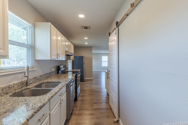 kitchen featuring white cabinets, a barn door, sink, and dark hardwood / wood-style flooring