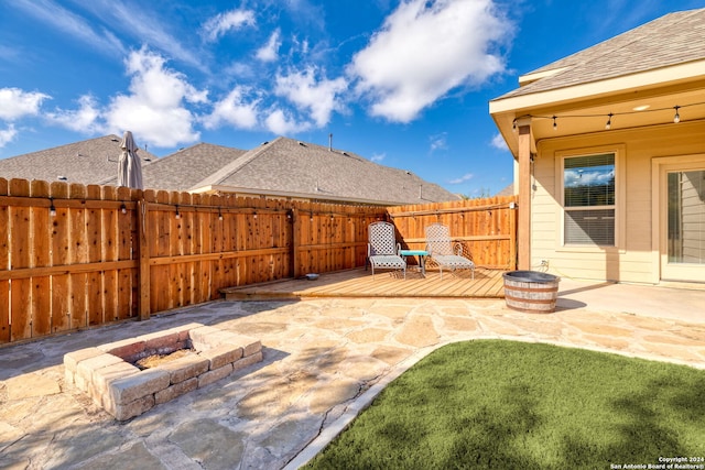 view of patio featuring an outdoor fire pit and a deck