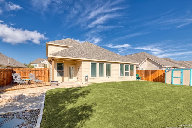 rear view of property featuring a patio area, a deck, and a lawn