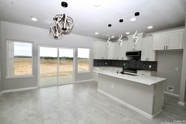 kitchen featuring white cabinetry, hanging light fixtures, and a healthy amount of sunlight