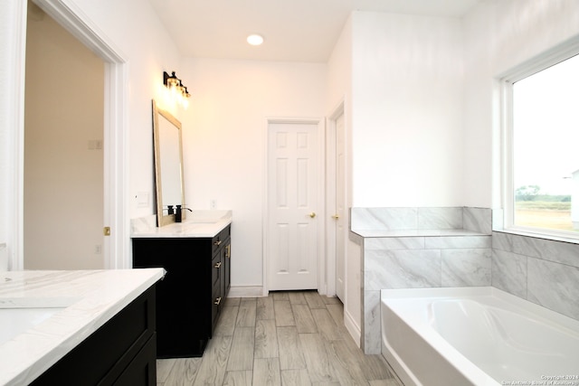 bathroom featuring hardwood / wood-style flooring, vanity, and a bathing tub