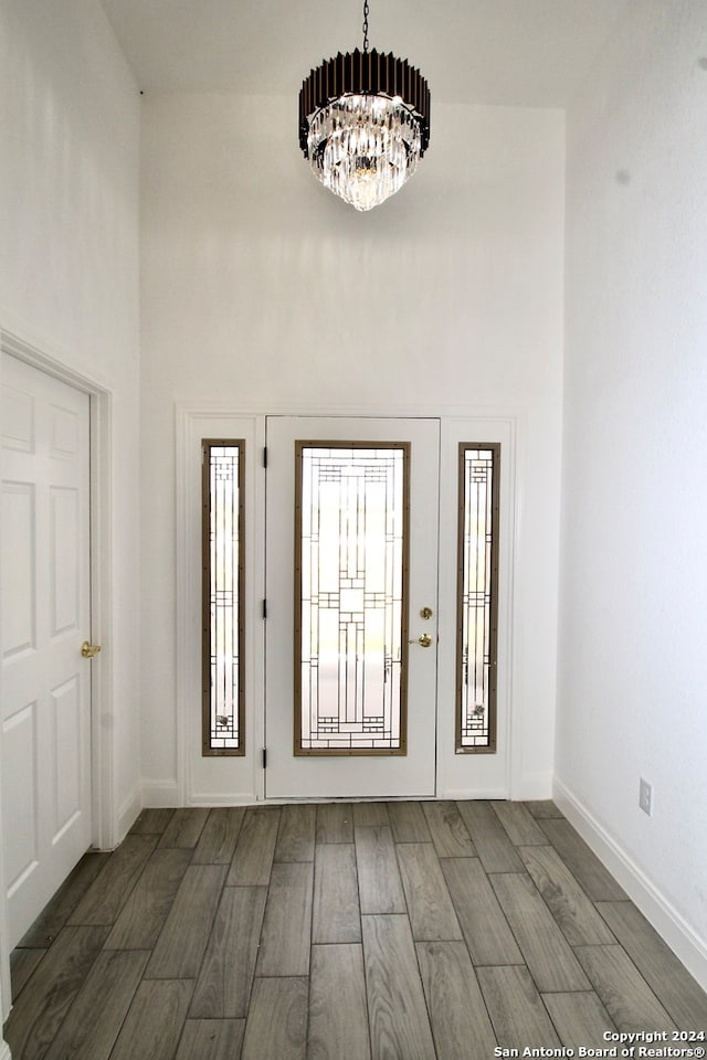 foyer featuring a chandelier, dark hardwood / wood-style floors, and a towering ceiling