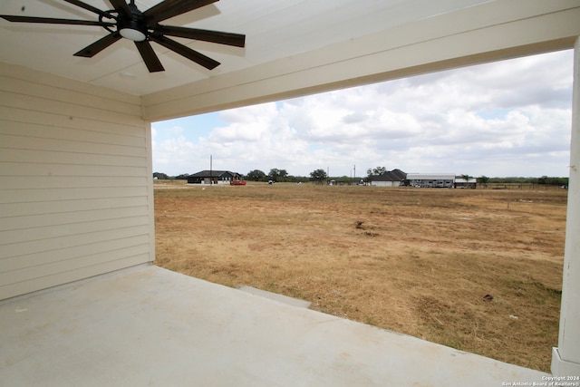 view of yard featuring ceiling fan and a patio