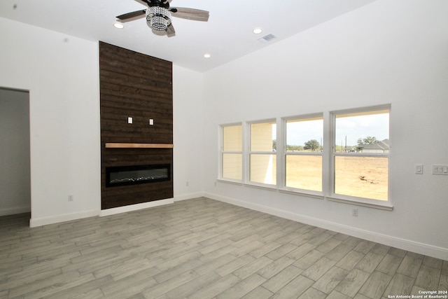 unfurnished living room with light hardwood / wood-style flooring, a fireplace, and ceiling fan