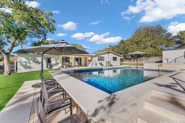 view of swimming pool featuring an outbuilding, a yard, and a patio