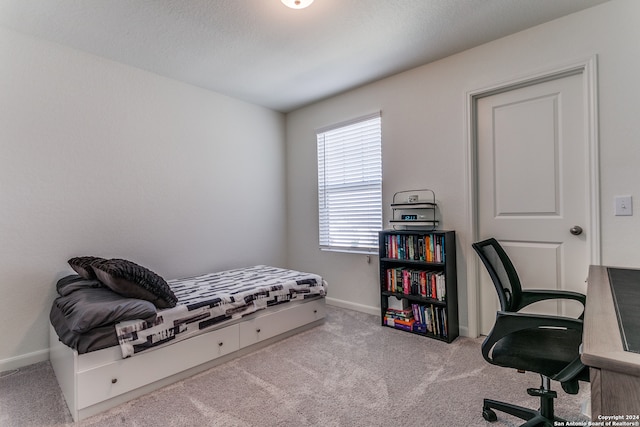 bedroom with light carpet and a textured ceiling