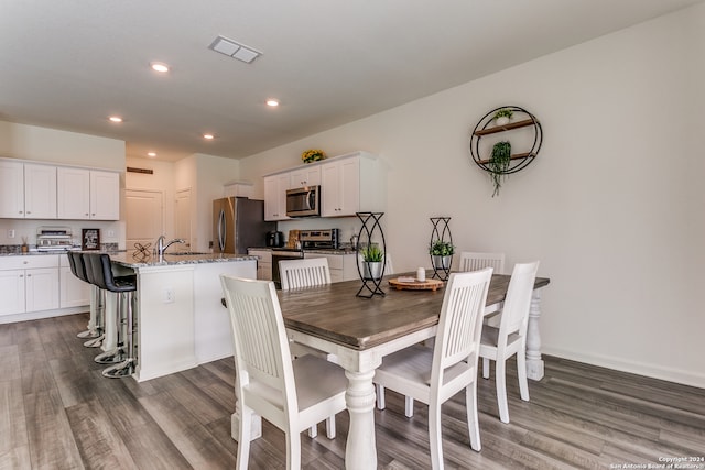 dining room featuring dark wood-type flooring and sink