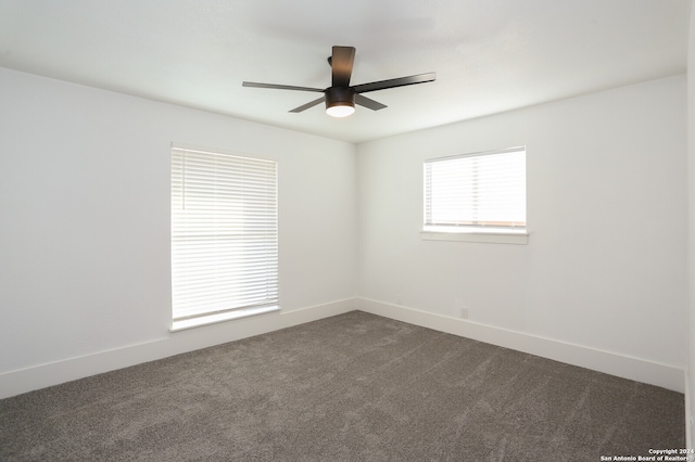 empty room with dark carpet and ceiling fan