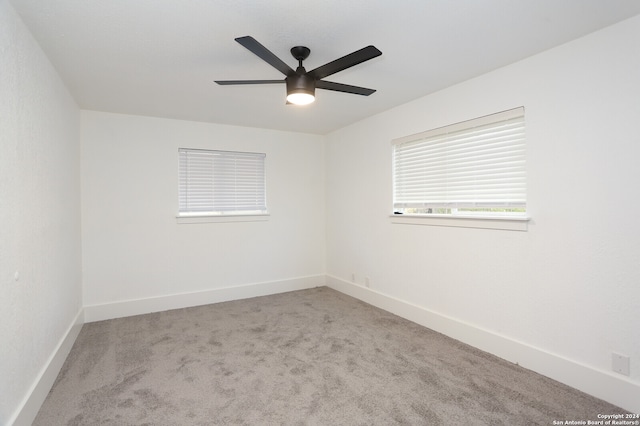 empty room featuring light colored carpet and ceiling fan