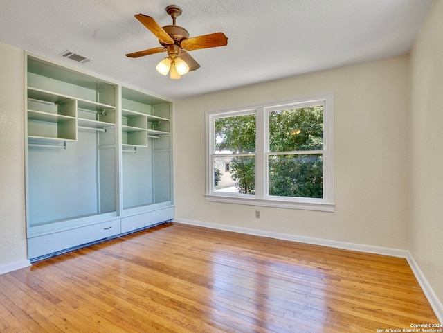 empty room featuring a textured ceiling, light hardwood / wood-style floors, and ceiling fan