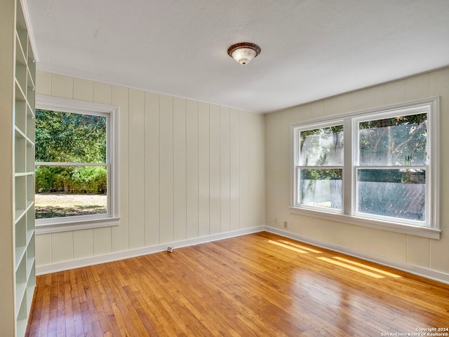 spare room with wood walls and hardwood / wood-style floors