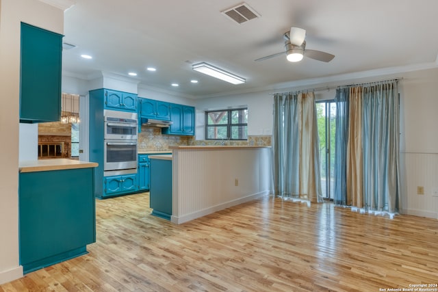 kitchen featuring ornamental molding, light hardwood / wood-style floors, ceiling fan, and stainless steel double oven