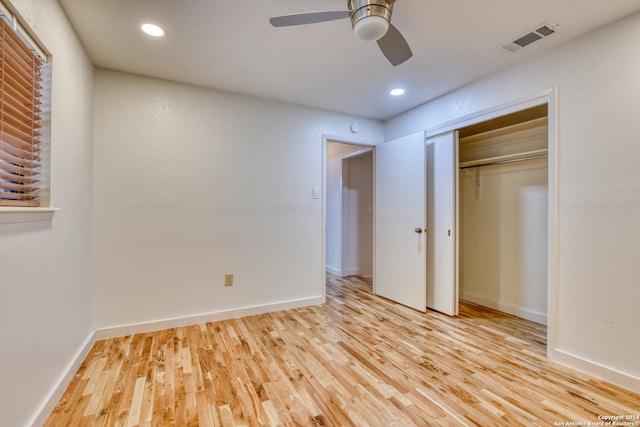 unfurnished bedroom featuring light hardwood / wood-style floors, ceiling fan, and a closet