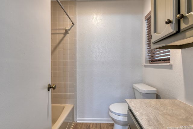 full bathroom featuring hardwood / wood-style flooring, vanity, toilet, and tiled shower / bath