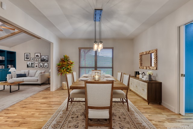 dining area featuring light hardwood / wood-style flooring, a notable chandelier, and lofted ceiling