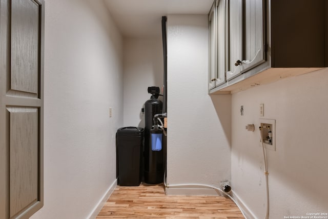 laundry room featuring washer hookup, cabinets, and light hardwood / wood-style flooring