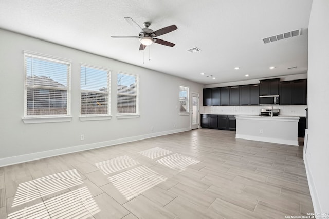 unfurnished living room featuring ceiling fan