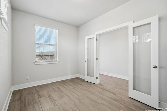 unfurnished bedroom featuring french doors and light wood-type flooring