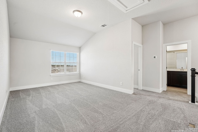 spare room featuring sink, vaulted ceiling, and light carpet