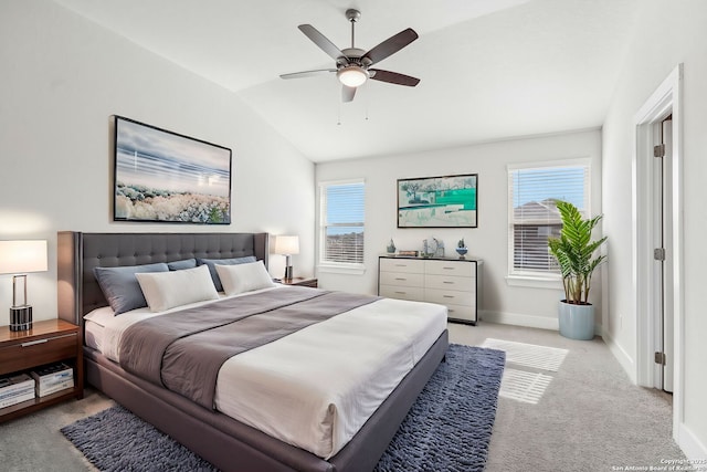 bedroom with multiple windows, vaulted ceiling, light colored carpet, and ceiling fan