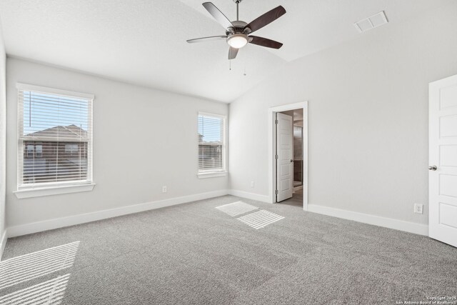 unfurnished bedroom with a spacious closet, vaulted ceiling, ceiling fan, and carpet flooring