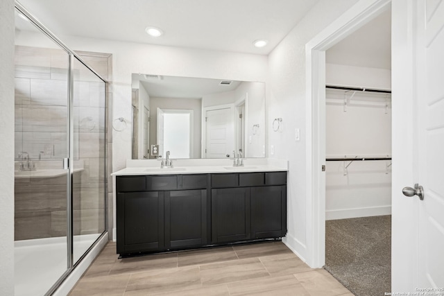 bathroom with vanity and a shower with door