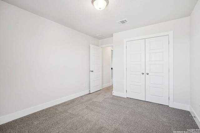 unfurnished bedroom with a closet and carpet flooring