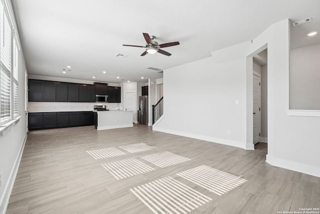 unfurnished living room featuring ceiling fan