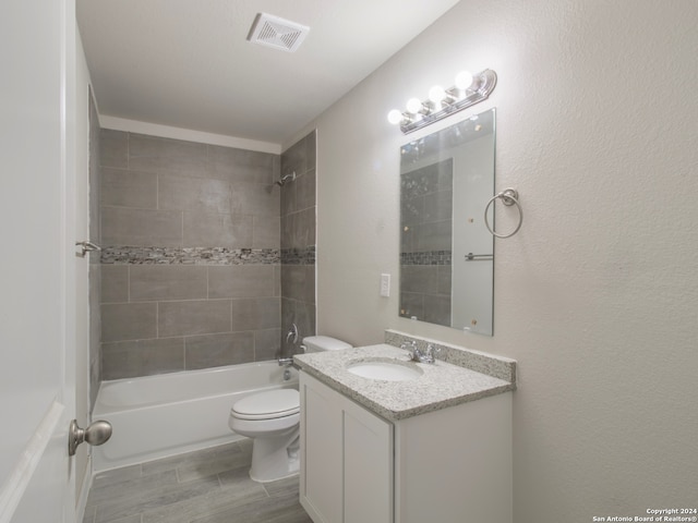 full bathroom with vanity, toilet, wood-type flooring, and tiled shower / bath