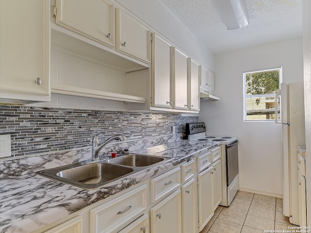 kitchen featuring decorative backsplash, a textured ceiling, light tile patterned flooring, sink, and white appliances