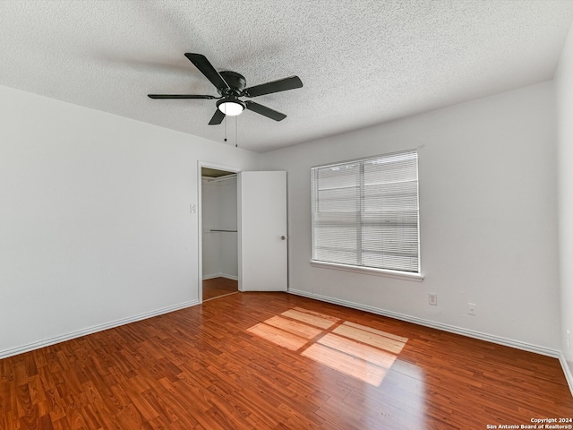 unfurnished bedroom with a closet, a textured ceiling, hardwood / wood-style flooring, and ceiling fan