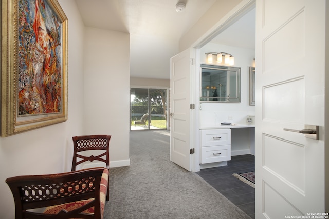 interior space with built in desk and dark colored carpet